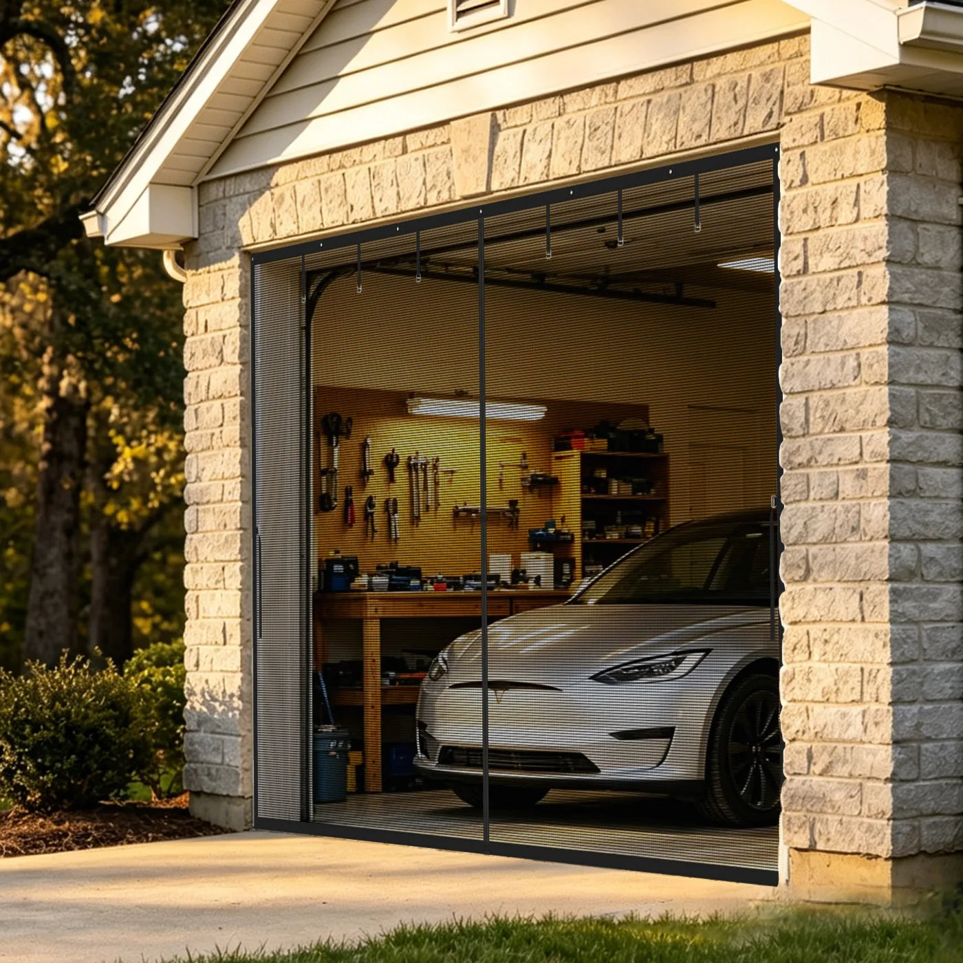 A closed magnetic garage screen door over a single-car garage with a Tesla parked inside.